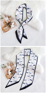Détail d'un long foulard en soie avec motifs baleines sur fond en peluche douce
