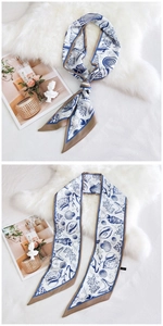 Détail d'un long foulard en soie aux motifs marins bleus avec des coquillages et étoiles