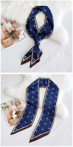 Détail d'un foulard Twilly bleu marine à motifs floraux sur fond de fausse fourrure