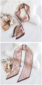 Détail d'un foulard en soie rose à motifs floraux sur fourrure blanche et magazine