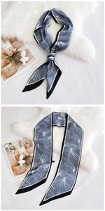Détail d'un foulard en soie bleu gris à motif floral noué sur une fourrure blanche