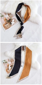 Détail d'un foulard étroit en soie au design géométrique avec une texture lisse