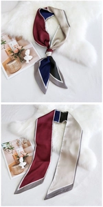 Détail d'un foulard en soie color-block noué montrant la texture satinée et le motif géométrique