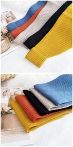 Detailed view of thick ribbed knit scarves in ginger, black, grey, red, and blue tones