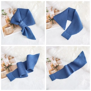 Close-up of navy blue knitted scarf with vertical ribbed texture and soft fabric