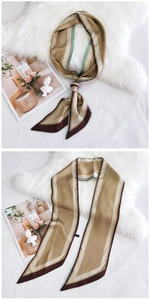 Gros plan d'un foulard en soie marron doré à rayures géométriques sur tissu blanc doux