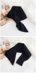 Detail view of black ribbed knit scarf showing thick woven texture and cross-over design