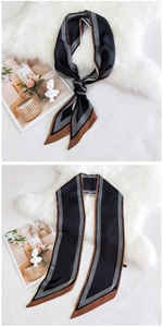 Détail d'un foulard long élégant en satin avec des motifs géométriques à rayures