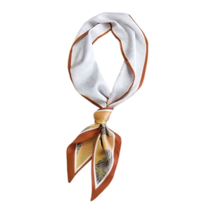 Foulard soyeux avec bordures orange et imprimés abstraits noué de manière élégante