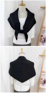 Detail of black knitted triangle shawl featuring soft texture and front tie knot style