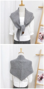 Detailed knit texture of grey wool shawl with stylish brown leather brand tag
