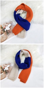 Detail of soft tri-color knitted scarf in orange, royal blue, and beige color blocks