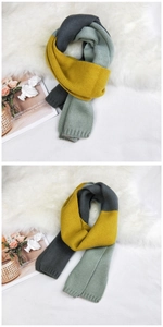 Detail of three-color knit scarf in ginger, grey, and green on soft faux fur