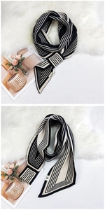 Detail of knitted scarf featuring black and white geometric patterns and stripes