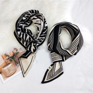 Knit leopard zebra pattern long scarf with stylish brand tag on soft plush background