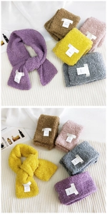 Detailed texture of colorful curly plush scarves showing crossed hole design and brand label