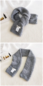 Macro detail of soft grey fleece scarf with Hutton brand label and curly wool texture