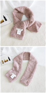Detail of pink teddy fleece scarf with slot design and woven label on knit background