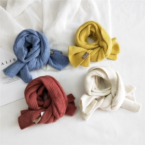 Set di sciarpe in maglia spessa nei colori blu giallo rosso e bianco su tessuto