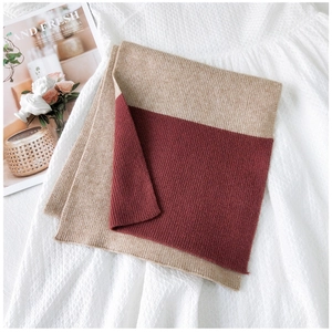 Dettaglio della trama a maglia a coste su sciarpa bicolore beige e bordeaux