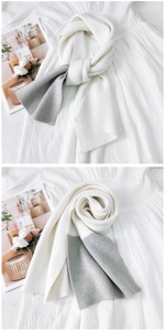 Dettaglio della sciarpa in maglia bicolore beige e grigio chiaro con varie trame