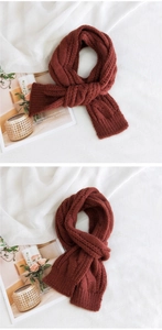 Macro view of burgundy knitted scarf featuring thick cable stitch and ribbed textures