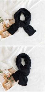Close-up of black knit scarf showing thick cable textures and warm vertical weave patterns