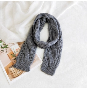 Close-up of dark grey cable knit pattern on thick warm winter scarf for women