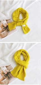 Detail of yellow cable knit scarf showing intricate texture and warm weave pattern