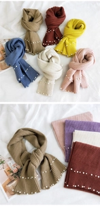 Close-up of knit texture with embedded pearls on a collection of colorful winter scarves