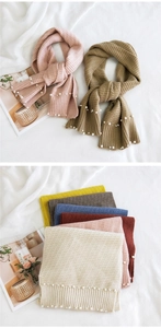 Detail of knitted scarf with pearl accents and ribbed texture in various colors