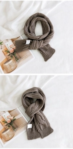 Detailed view of brown cable knit scarf with thick wool texture and decorative woven pattern