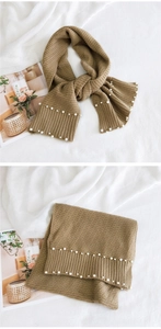 Detailed knit texture of brown scarf with decorative white pearls and ribbed weave