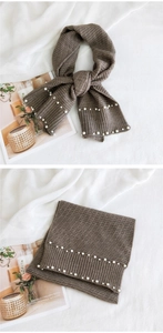Close-up of dark brown knit scarf with double-row pearl beads and ribbed texture