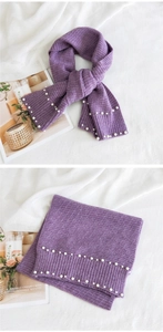 Detail of light purple knitted scarf featuring elegant pearl embellishments and ribbed edges