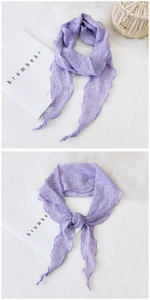 Détail d'une écharpe en coton et lin plissée violet clair avec texture douce et froissée