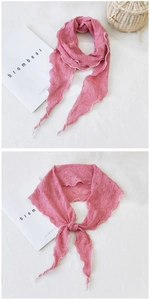 Détail d'une écharpe en coton plissé rose avec bords à volants et surpiqûres blanches