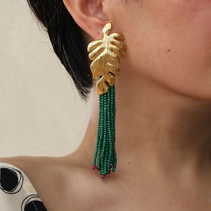 Exaggerated golden monstera leaf earrings with long dark green beaded tassels for women
