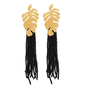 Golden Monstera leaf earrings with long black seed bead tassels in bohemian style