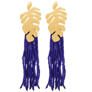 Detail view of golden tropical leaf alloy stud with long navy blue beaded tassels
