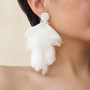 Detail of white organza petal tassel earrings with handmade beaded studs on a model