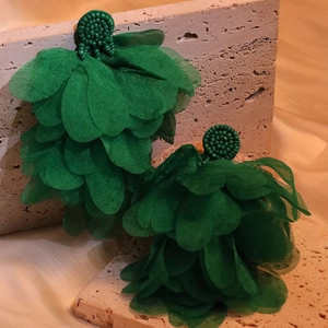 Detailed view of dark green handmade floral earrings with layered organza and beads