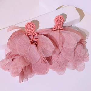 Detailed view of handmade pink beaded base and layered fabric tassel earrings