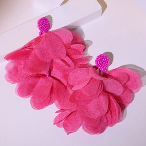 Macro detail of magenta fabric flower earrings with beaded studs and tiered petals