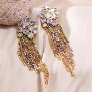 Detail view of long tassel earrings with AB rhinestones on beige satin fabric