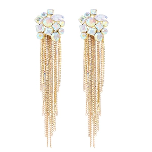 Macro detail of long gold tassel earrings with sparkling rhinestones and opal crystals