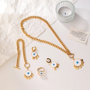 Detail of gold-plated evil eye jewelry set with blue enamel and coin tassel charms