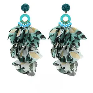 Detail of long handmade fabric floral tassel earrings with blue beads and spotted pattern