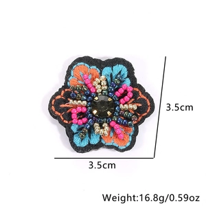 Handmade embroidered floral bead earring patch with orange and blue petals and black gem