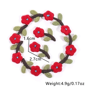 Detailed view of red floral embroidery patches with green leaves and size markings